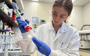 A photo of Alessandra Coogan using a pipette in a lab