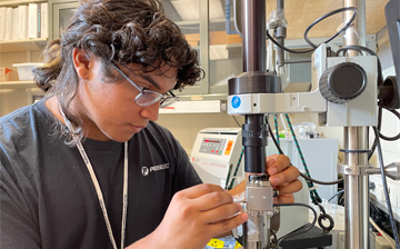 A photo of Jacob Arras using an atomic force microscope