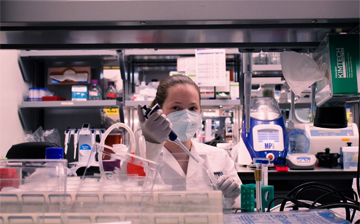 A photo of Maya Evohr using a pipette in a lab space