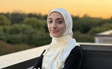 Photo of a woman with a hijab in front of a sunset