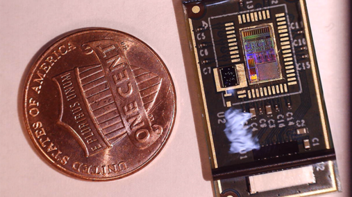 Tiny wearable sensor next to a penny