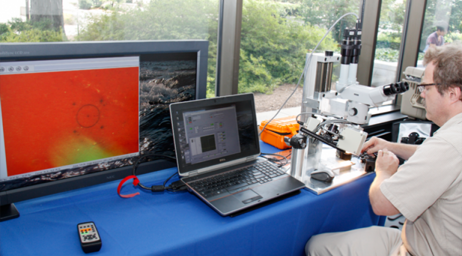 A Carnegie Mellon research team member demonstrates the microsurgery workstation for retinal surgery.