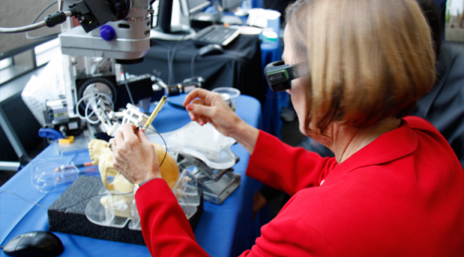 Dr. Christine Kelley, NIBIB Division of Discovery Science and Technology Division Director, uses the microsurgery workstation from Johns Hopkins and Carnegie Mellon to learn about retinal surgery improvements. The workstation reduces the impact of human limitations in image and information processing during surgery and enbales new therapeutic approaches.