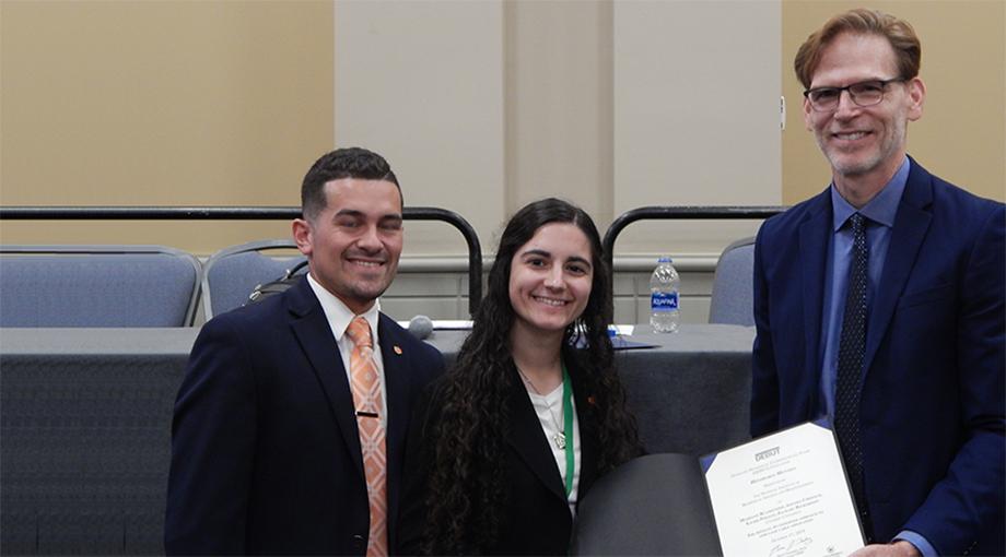 Students Xavier Peralta and Amanda Chernick of Virginia Tech won the VentureWell Design Excellence prize for developing a compact and supportive arm exoskeleton that can be worn under a shirt. They are pictured here with NIBIB Director Dr. Bruce Tromberg