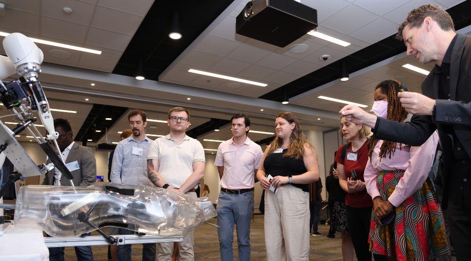 Axel Krieger (far right) explains how their autonomous surgical robot can perform soft-tissue surgery to a group of congressional staff.